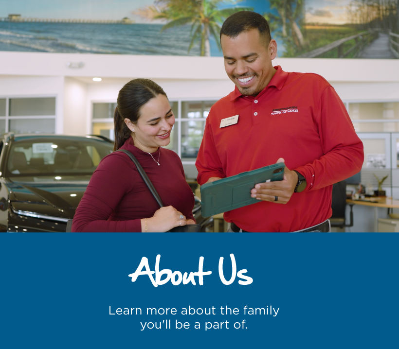 Text reads, “About Us. Learn more about the family you'll be a part of.” Above the text, a customer and dealership employee stand in a showroom looking at a tablet together.